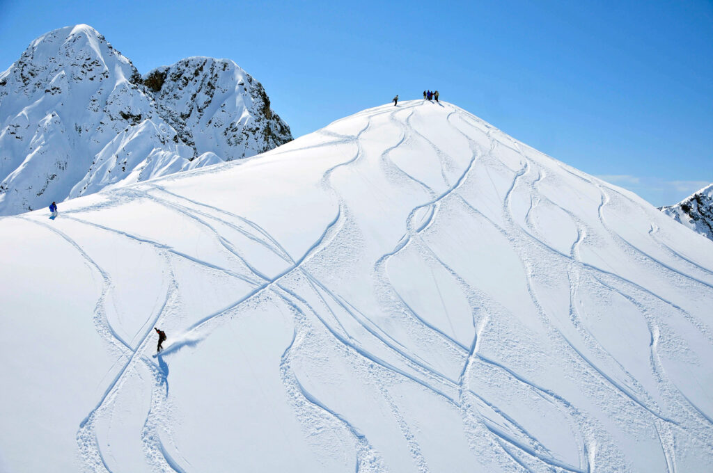 Un grupo de personas bajan esquiando por una montaña en Andorra