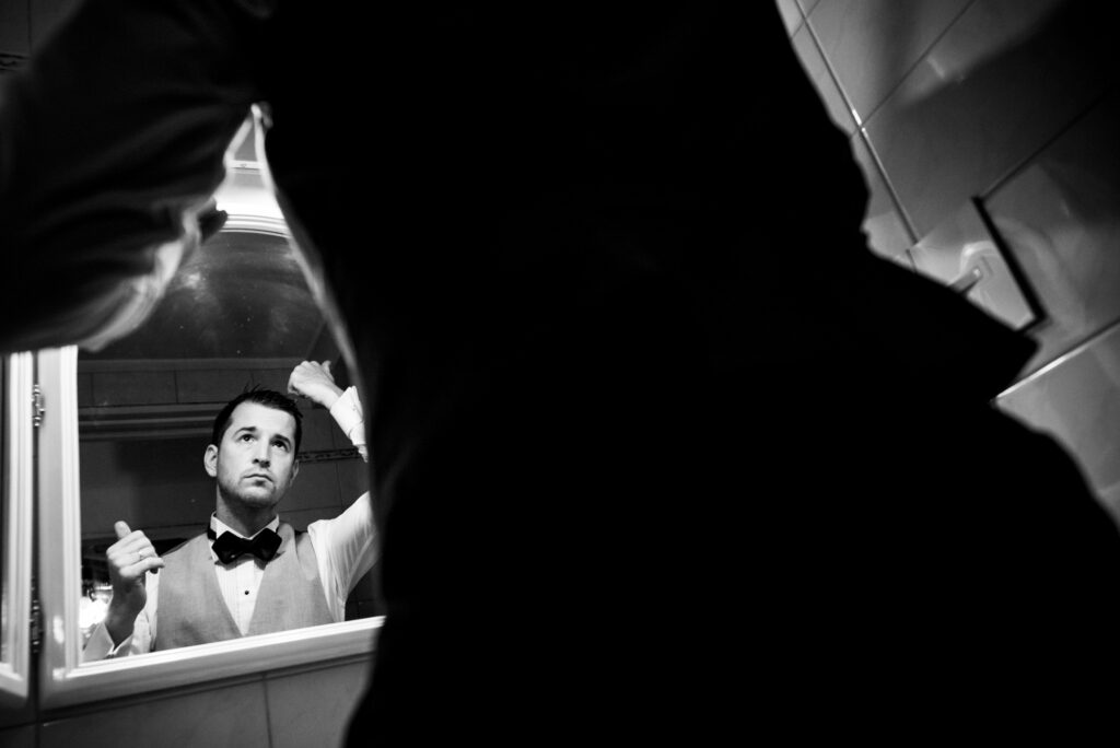 Un hombre se peina frente al espejo previo a su boda.