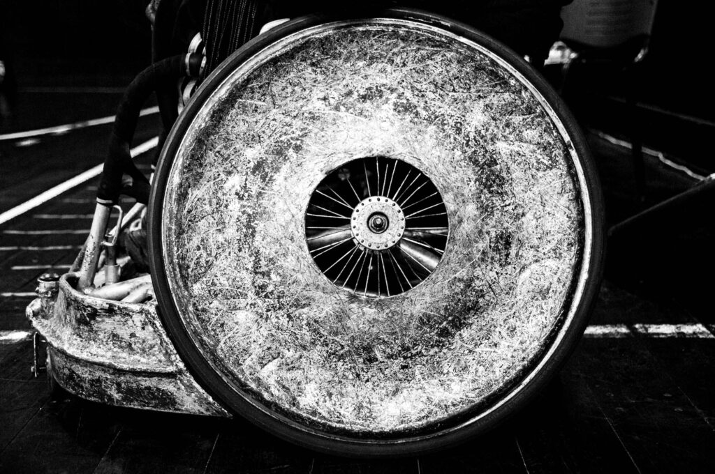 Rueda que se usa para hacer Rugby en silla de rueda con marcas, raspones y abolladuras.