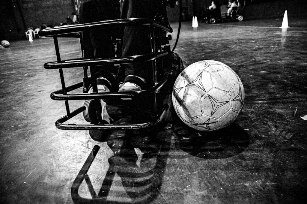 Primer plano de la protección de pies que tienen las sillas de ruedas motorizadas para controlar e impactar la pelota durante un partido de fútbol.