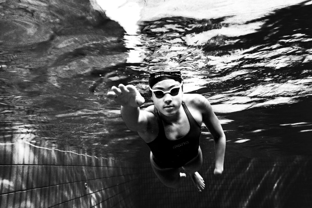Nadadora paralímpica mirando a cámara en una fotografía tomada bajo el agua.
