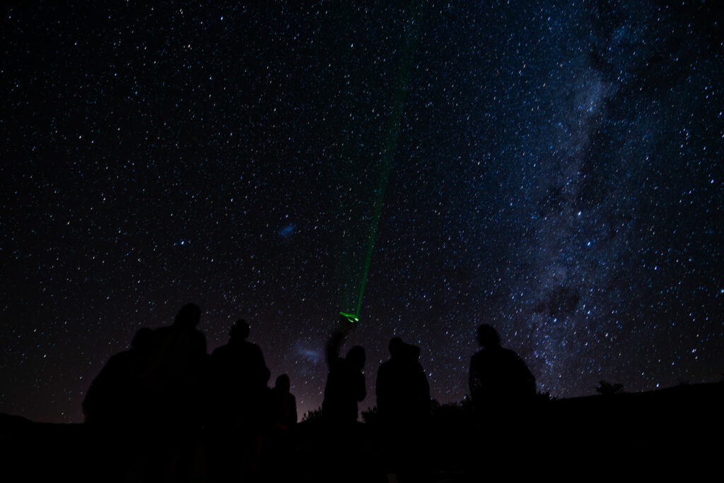 Un grupo de personas observan el cielo en una noche muy estrellada.