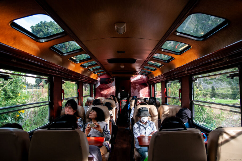 Turistas viajan en un tren con techo vidriado rumbo a Machu Picchu, Perú.