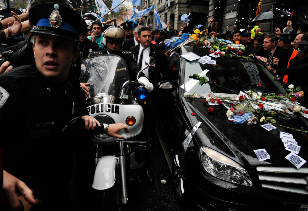 Del lado izquierdo de la imagen hay un cordón policial que acompaña el cortejo fúnebre del ex presidente Néstor Kirchner.